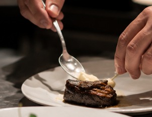A chef plating a dish by hand