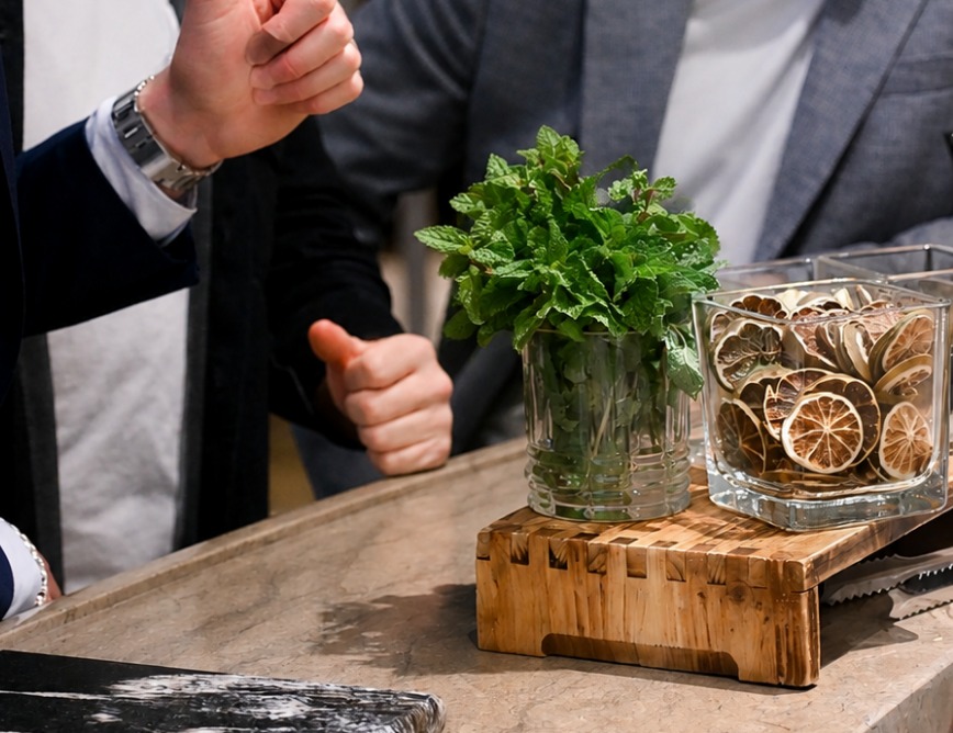 Colleagues gathered at a counter with fresh mint and dried citrus